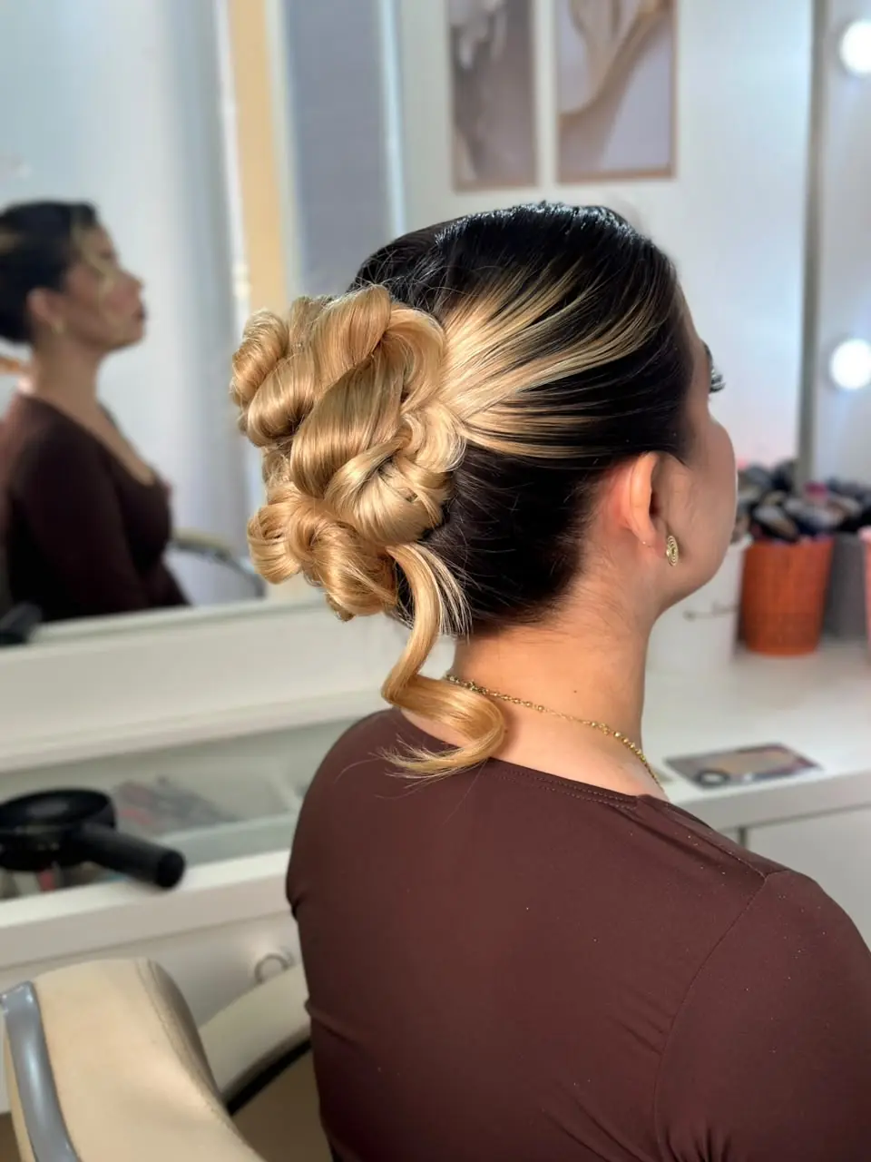 Penteado simples com coque trançado e mechas douradas