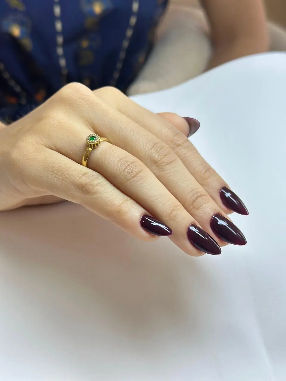 Unhas amendoadas com esmaltação vinho de acabamento brilhante